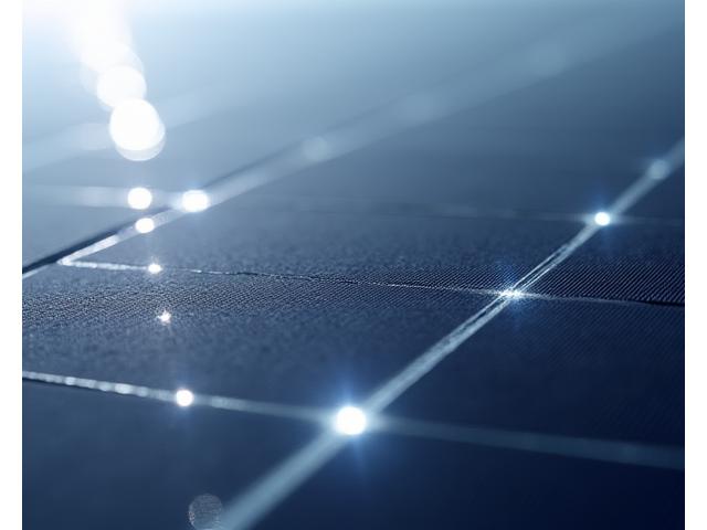Close-up of high-efficiency monocrystalline solar cells with subtle light reflections, illustrating advanced solar technology.